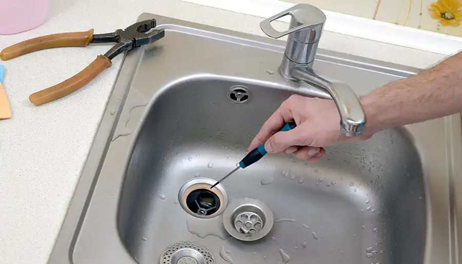 Plumber clearing a clogged drain using professional drain cleaning equipment