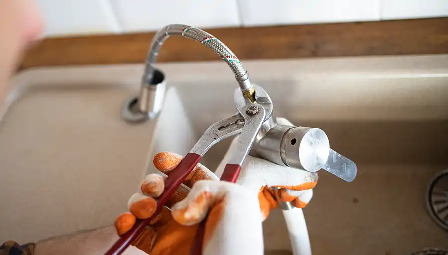 Plumber performing routine maintenance on residential plumbing system