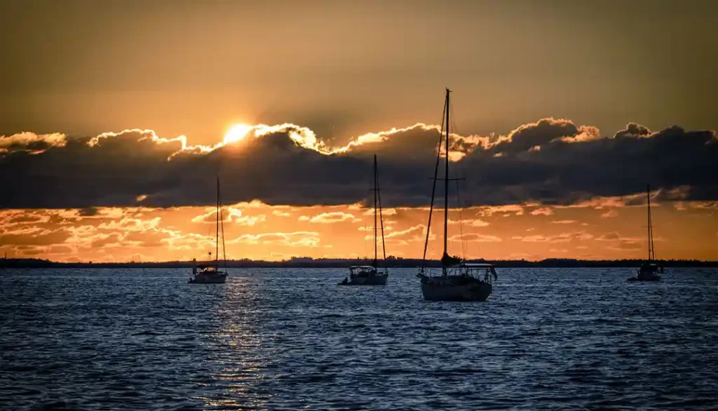 Punta Gorda harbor with boats docked along calm waters under a sunset sky