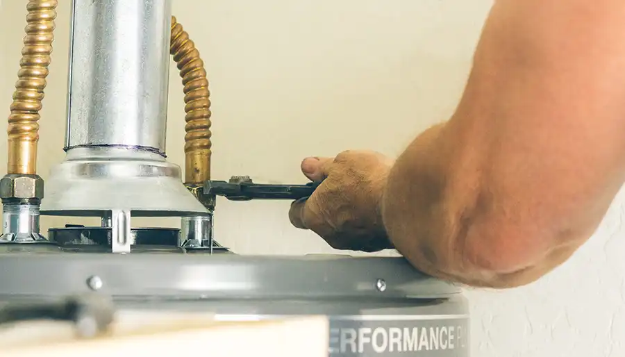 Technician installing a residential water heater in a utility room