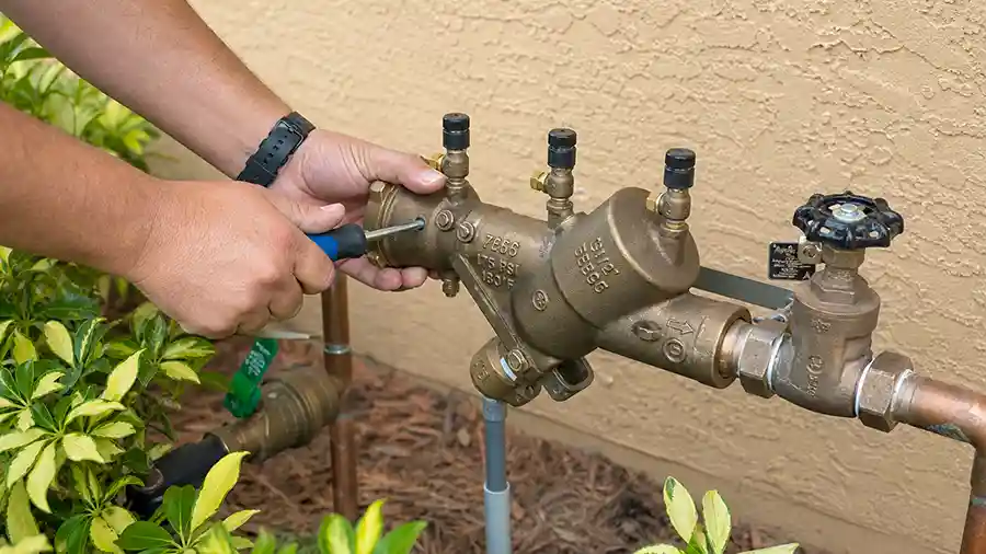Plumber repairs a residential backflow preventer